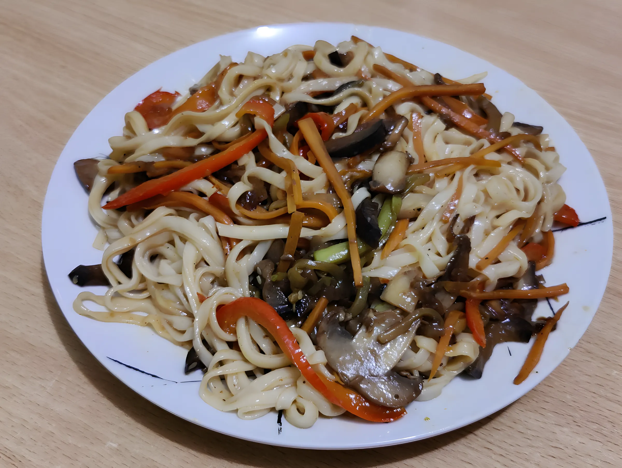 Opskrift på tilberedning af udon-nudler i wok med champignon, grøntsager, soja og asiatiske saucer